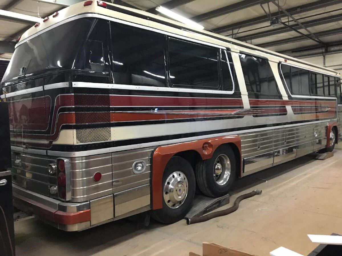 This image has an empty alt attribute; its file name is The-coach-in-Jay-Woods-shop-when-he-owned-it-notice-the-bumper-rub-strips-are-painted-burnt-orange.jpg