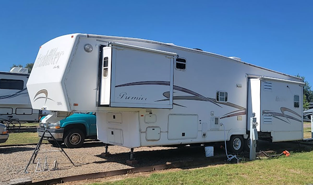 A 5th Wheel Trailer with a few tiny windows on this side.