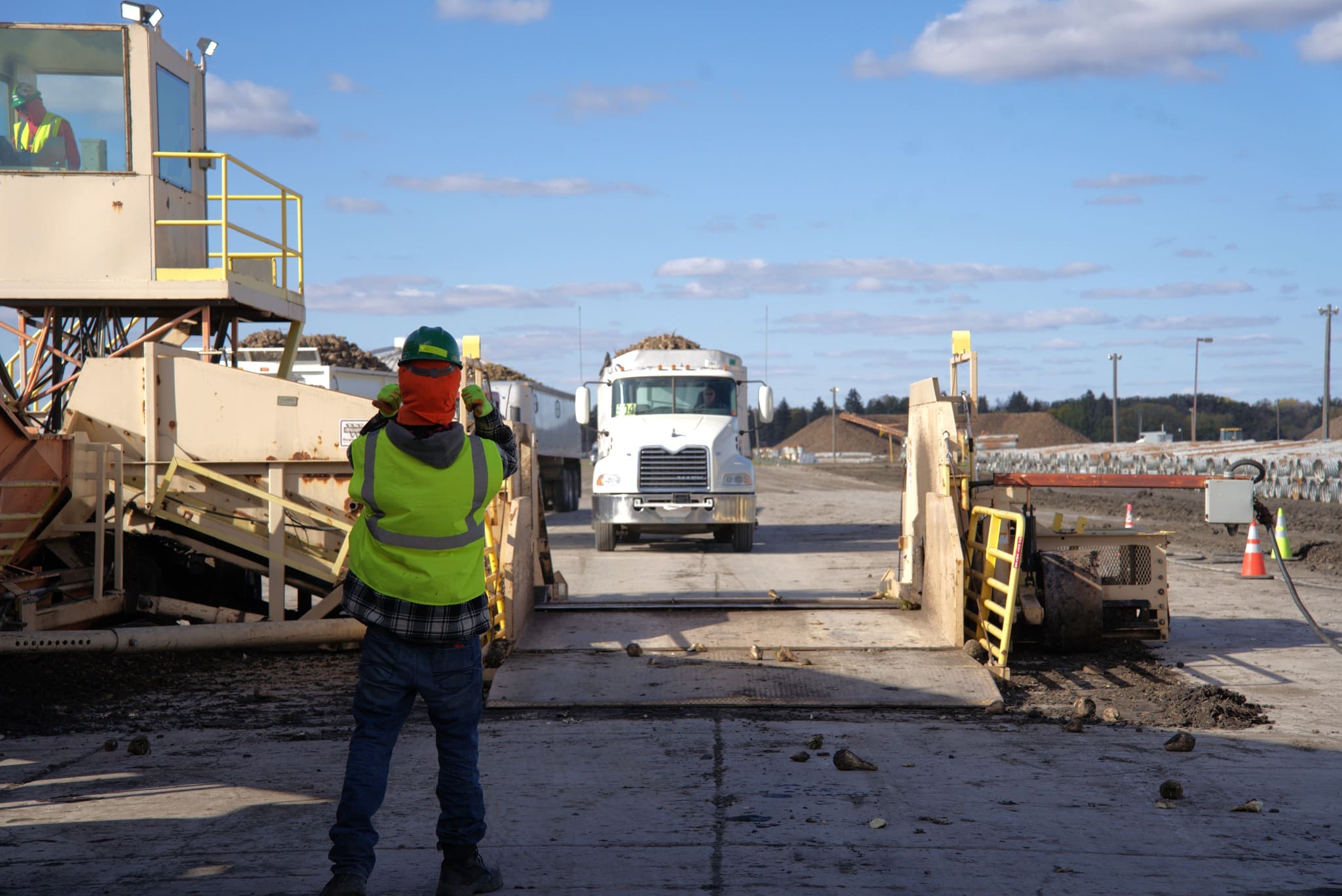 Guiding trucks into the end dump on a Piler. Guiding trucks into the end dump on a Piler.